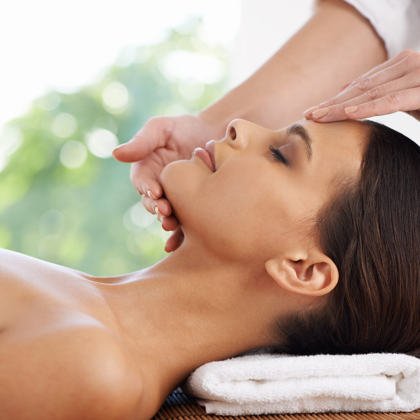 A young woman receiving a face massage